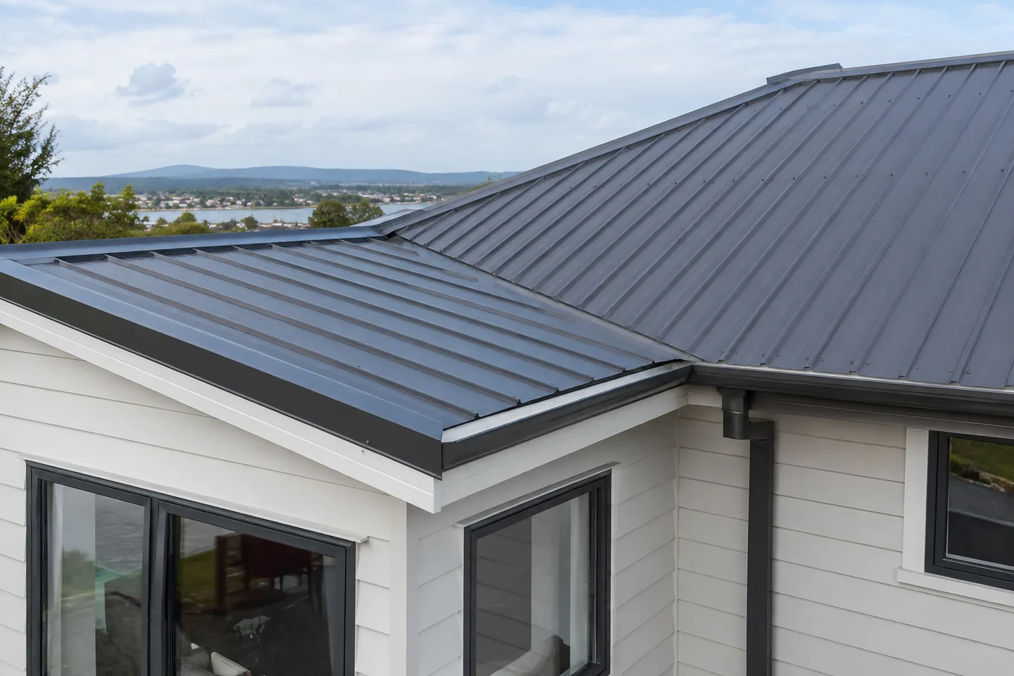 Roofing concept: a house extension roof meeting an existing metal roof
