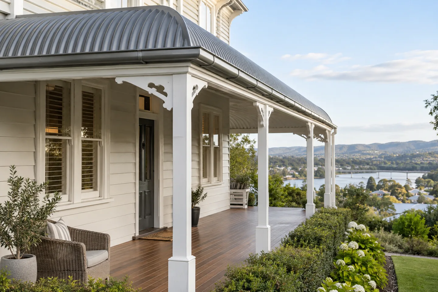 Roofing concept: a weatherboard villa veranda with a shallow curved metal roof